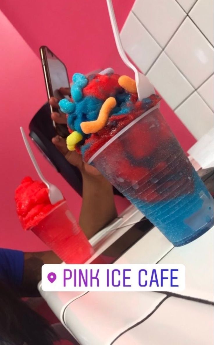 a person holding up a cup filled with candy