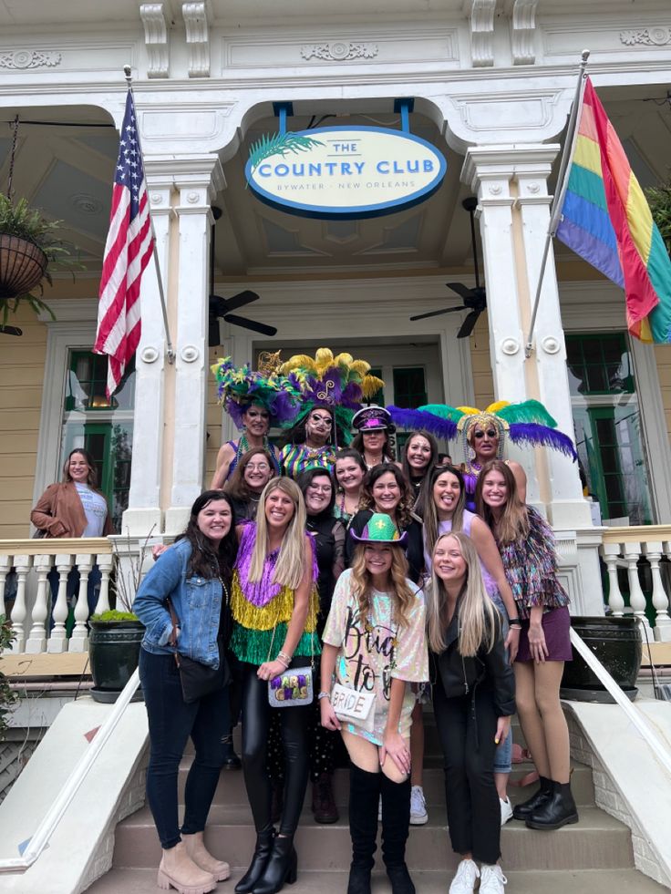 a group of women standing in front of a building with flags and decorations on it