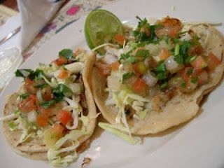 two tacos are sitting on a white plate