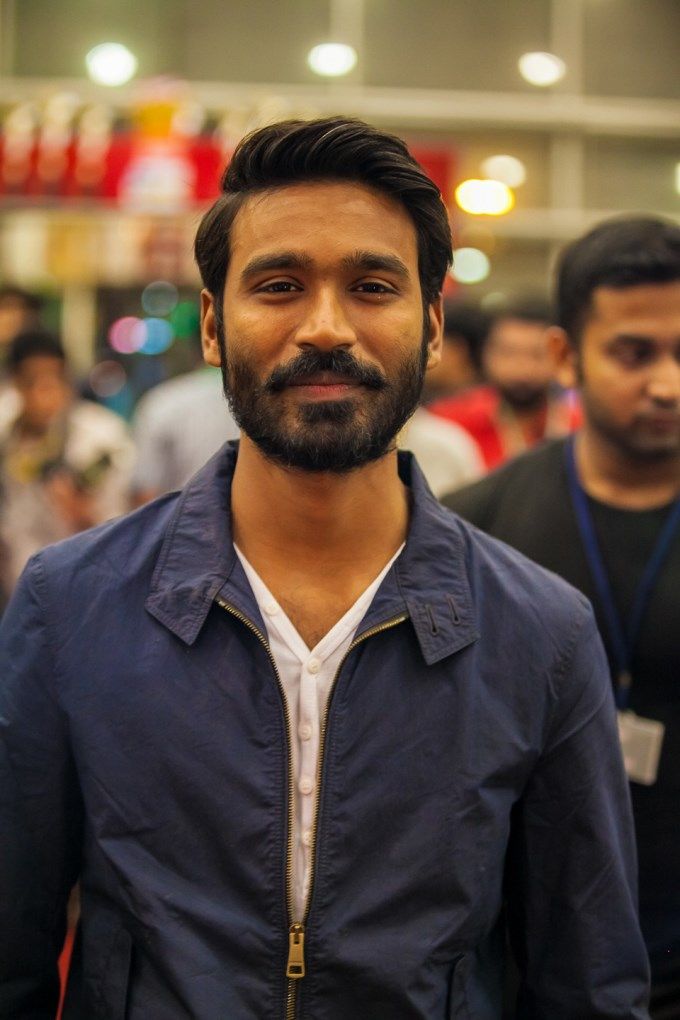 a man with a beard standing in front of a group of people at an event