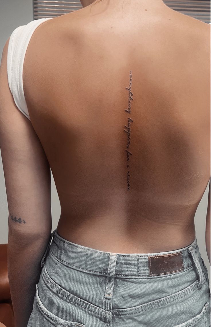 the back of a woman's upper body with writing on her left shoulder and right arm