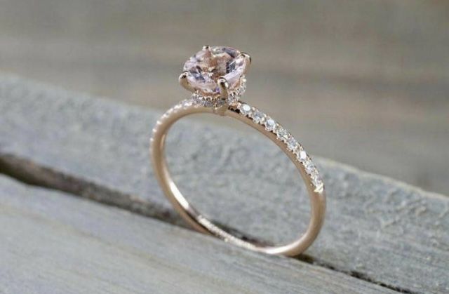 an engagement ring with a pink diamond on top