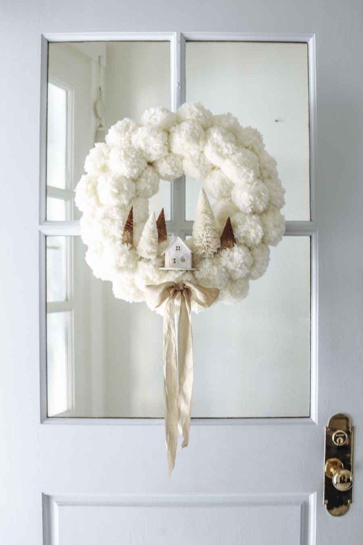 a white wreath hanging on the front door