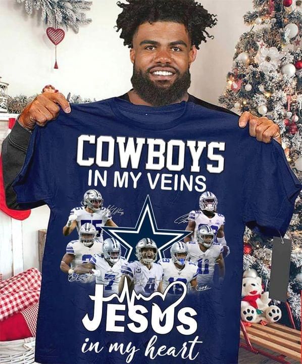 a man holding up a cowboys t - shirt in front of a christmas tree with his name