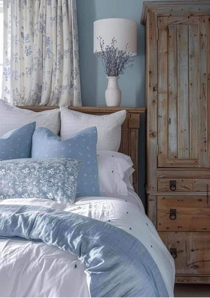 a bedroom with blue walls and white bedding