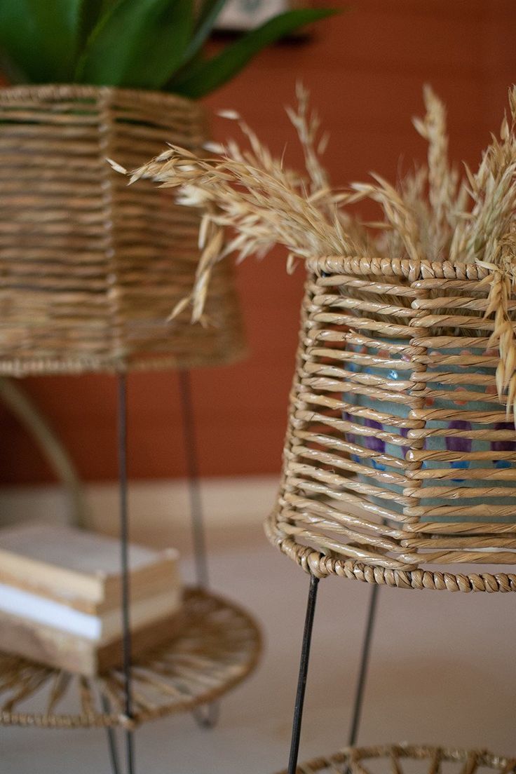 two wicker baskets sitting on top of a table next to each other with plants in them