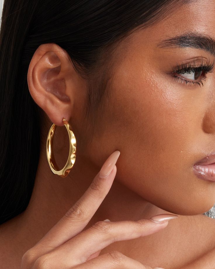 The ‘Noelle’ hoop earrings have an organic and freeform shape. There is a rounded spike pattern that goes around the outer edge of the earrings to give off a funky vibe. At the same time, the earrings look elegant and luxurious due to the high polish finish and shine. The earrings are constructed in 18k yellow gold or white gold plated over sterling silver metal. Each piece is hand polished and inspected to assure a high-quality finish. Closure: Hoop Stamp Approx. Measurement: Outer Length: 1.7 inches Outer Width: 7 inches Silver weight: Approx. 0.26 oz Bamboo Hoop Earrings, Chunky Hoop Earrings, Earring Sale, Shop Earrings, Post Earrings, Jewelry Pieces, Metallic Silver, Gold Earrings, 18k Gold