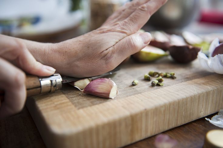 a person chopping up some food on a cutting board with garlic and an onion