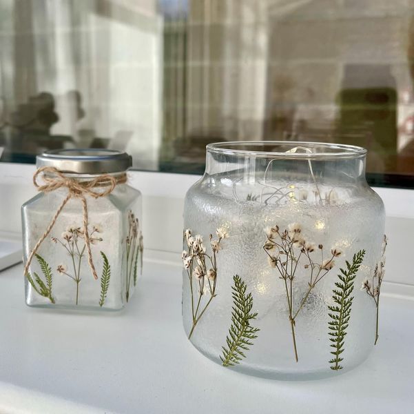 two glass jars with plants painted on them