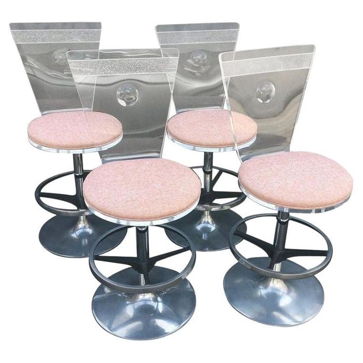 four stools with pink cushions and metal bases