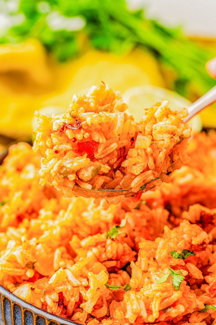 a spoon full of rice is being held up by someone's hand over the bowl