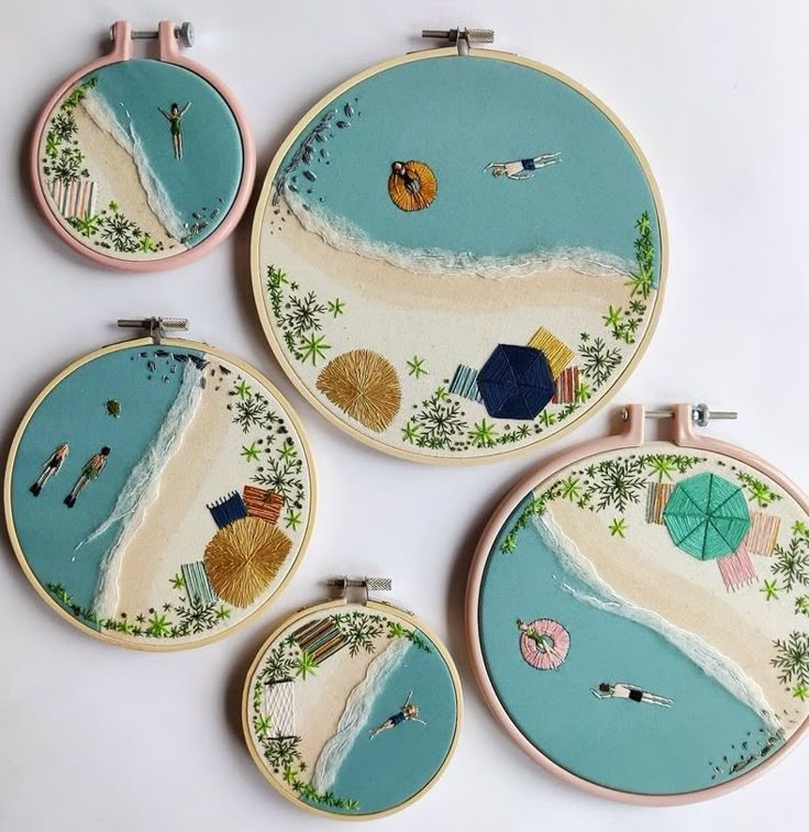 four hand embroidered beach scenes are displayed on the wall