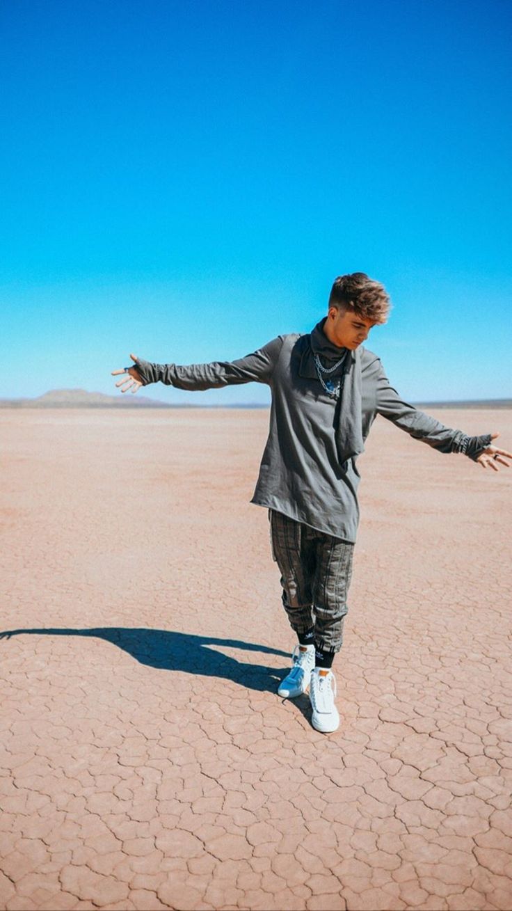 a man standing in the desert with his arms spread out and hands outstretched to the side