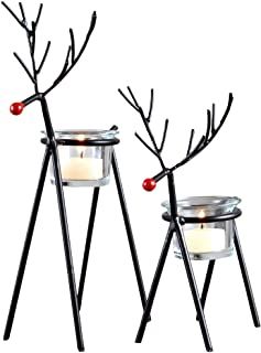 two metal reindeer candle holders sitting next to each other