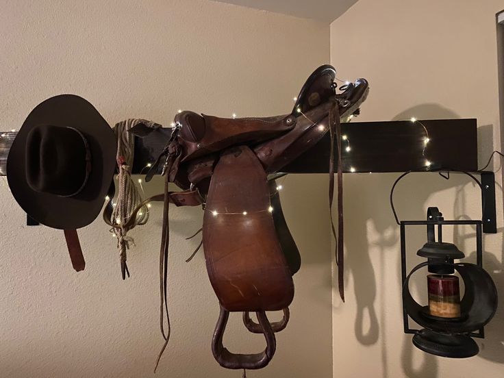 there is a horse saddle hanging on the wall next to a mirror and other items