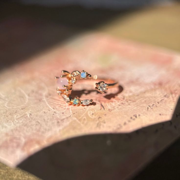 📌 Please Note: When adjusting the ring, please squeeze or expand the ring body slowly and gently. 💎 Materials: 14k Rose Gold Electroplated - more durable than regular platings Cubic Zirconia 📐 Size: Adjustable Open Design - Size 5+ Rose Gold Open Ring For Promise, Adjustable Dainty Rose Gold Moonstone Ring, Adjustable Rose Gold Flower Ring, Adjustable Pink Midi Rings, Pink Adjustable Open Midi Ring, Adjustable Pink Moonstone Round Ring, Adjustable Rose Gold Cubic Zirconia Rings, 14k Gold Celestial Opal Ring, Adjustable Rose Gold Open Crystal Ring