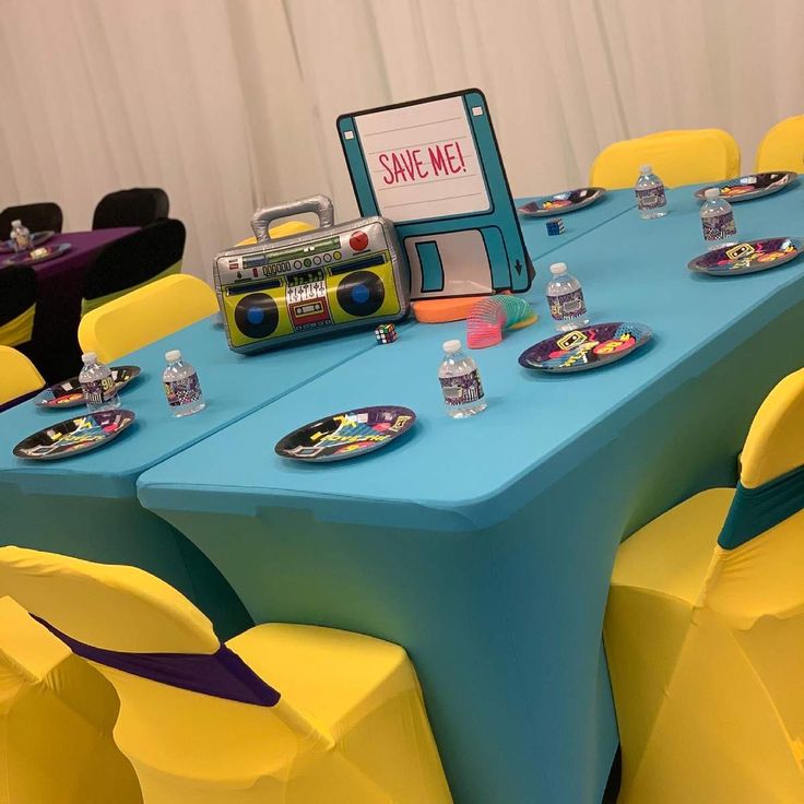 a blue table topped with yellow chairs next to a sign that says save me on it