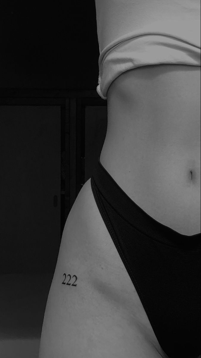 a woman's stomach with the number 22 tattooed on her lower side, in black and white