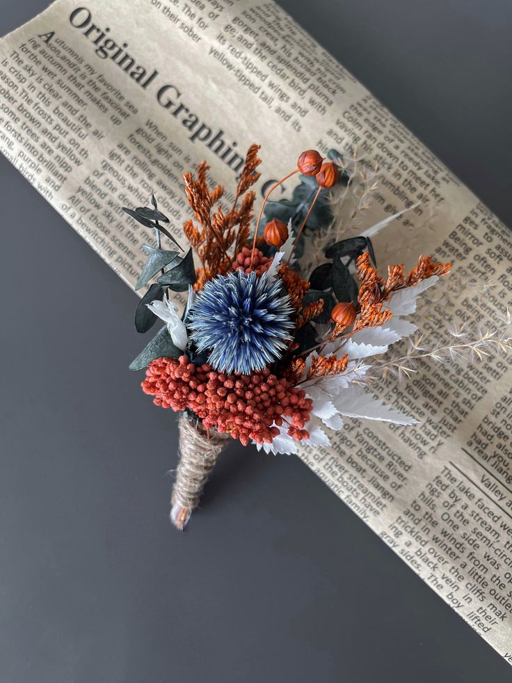 a bouquet of flowers sitting on top of an old newspaper page with the words original capital written in red, white and blue