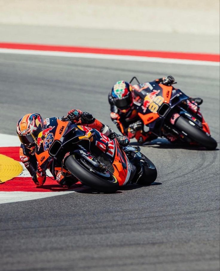 two people on motorcycles racing around a track