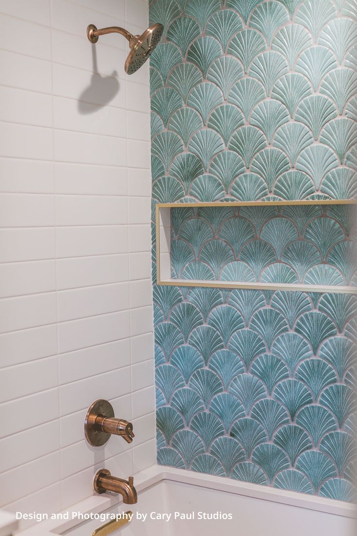 a bathtub with two faucets in front of a blue and white wall