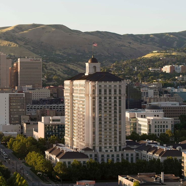 an aerial view of a city with tall buildings and mountains in the backgroud