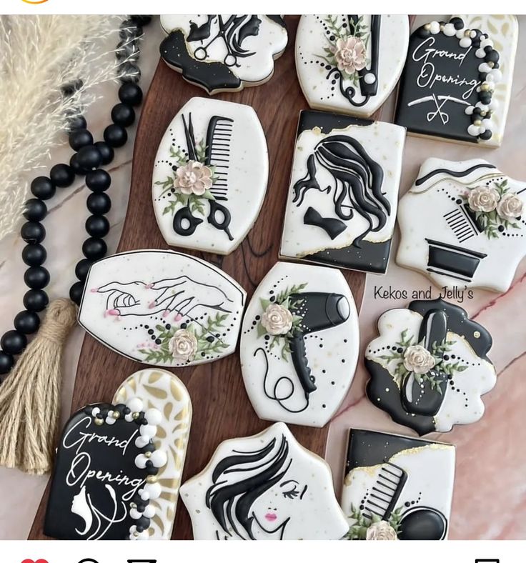 some decorated cookies are sitting on a wooden board with black and white decorations, including hair combs