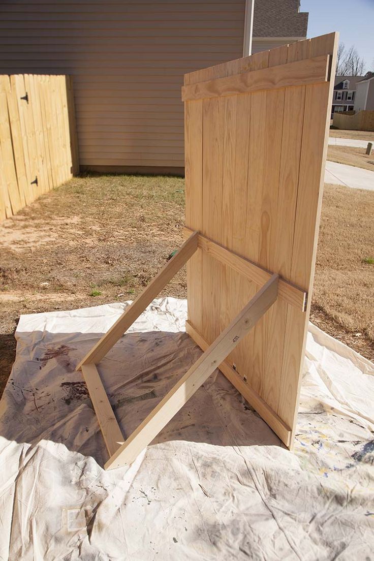 a piece of wood sitting on top of a tarp covered ground next to a building