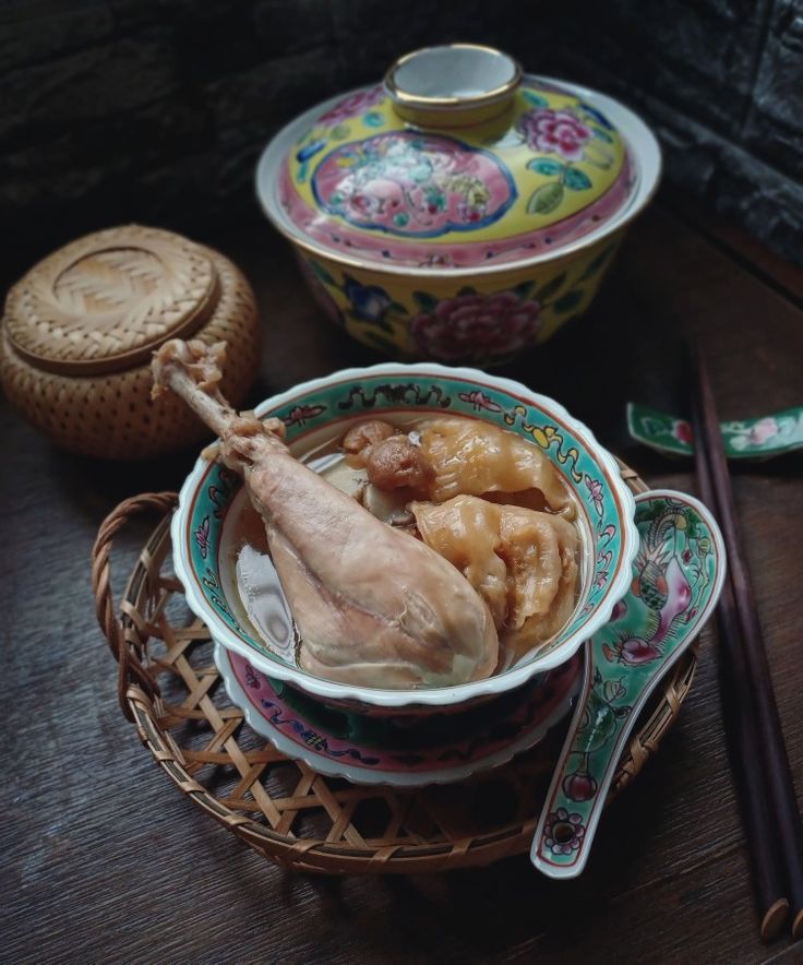 a bowl filled with food next to chopsticks and a container on a table