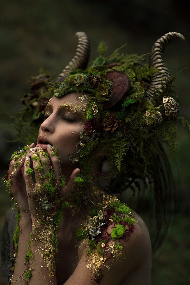 a woman is covered in moss and plants