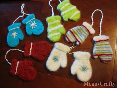 several mittens and gloves hanging from strings on a table