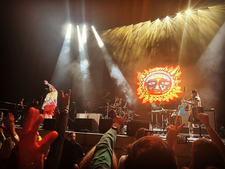 a group of people standing on top of a stage with their hands in the air