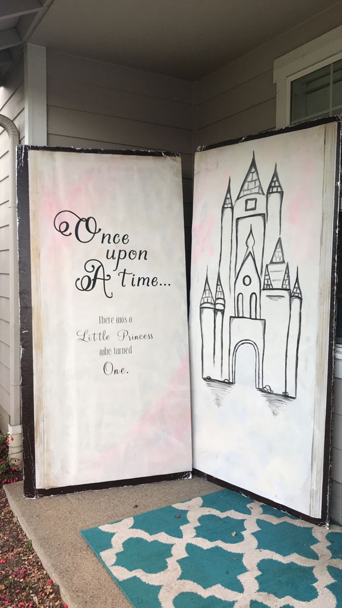 two canvass that are sitting on the ground in front of a house, one has an image of a castle