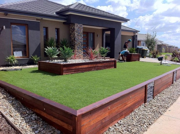 a house that has grass in front of it and some plants on the lawn outside