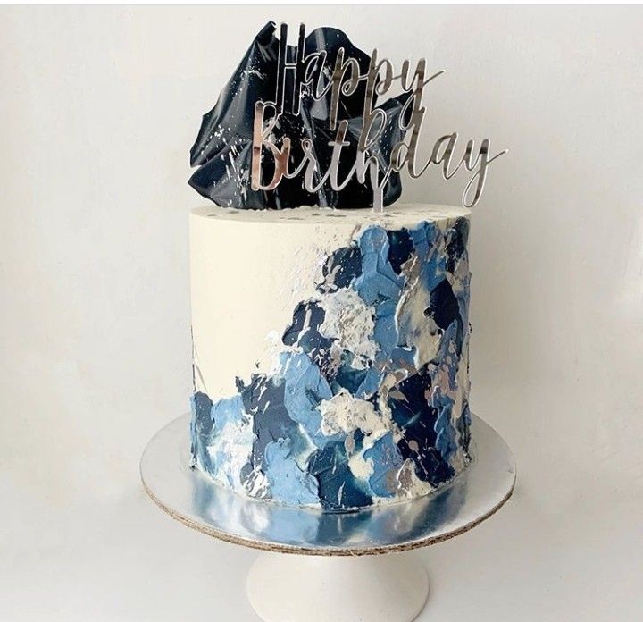 a blue and white birthday cake with the words happy birthday on it's top