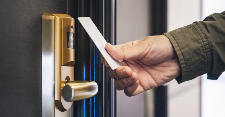 a person is holding a piece of paper in their hand near a door handle on a black door