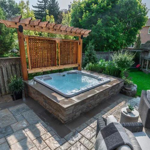 an outdoor hot tub in the middle of a backyard