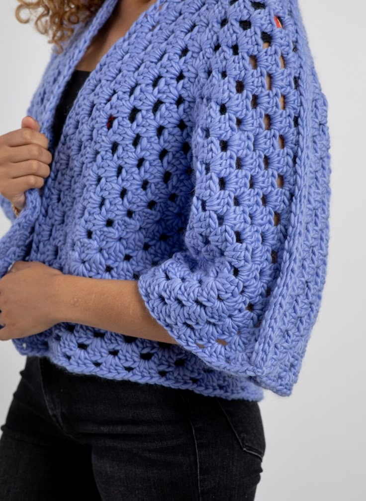 a woman wearing a blue crocheted sweater