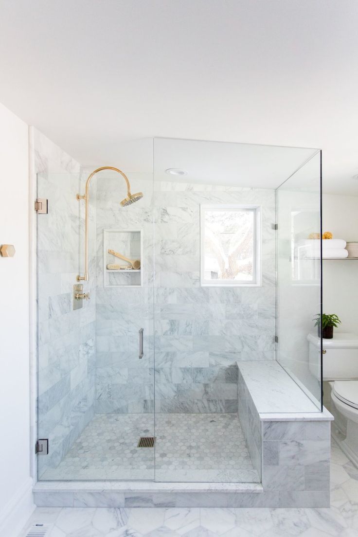 a walk in shower sitting next to a toilet