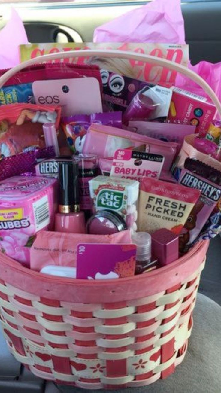 a pink basket filled with lots of different types of items in the back seat of a car