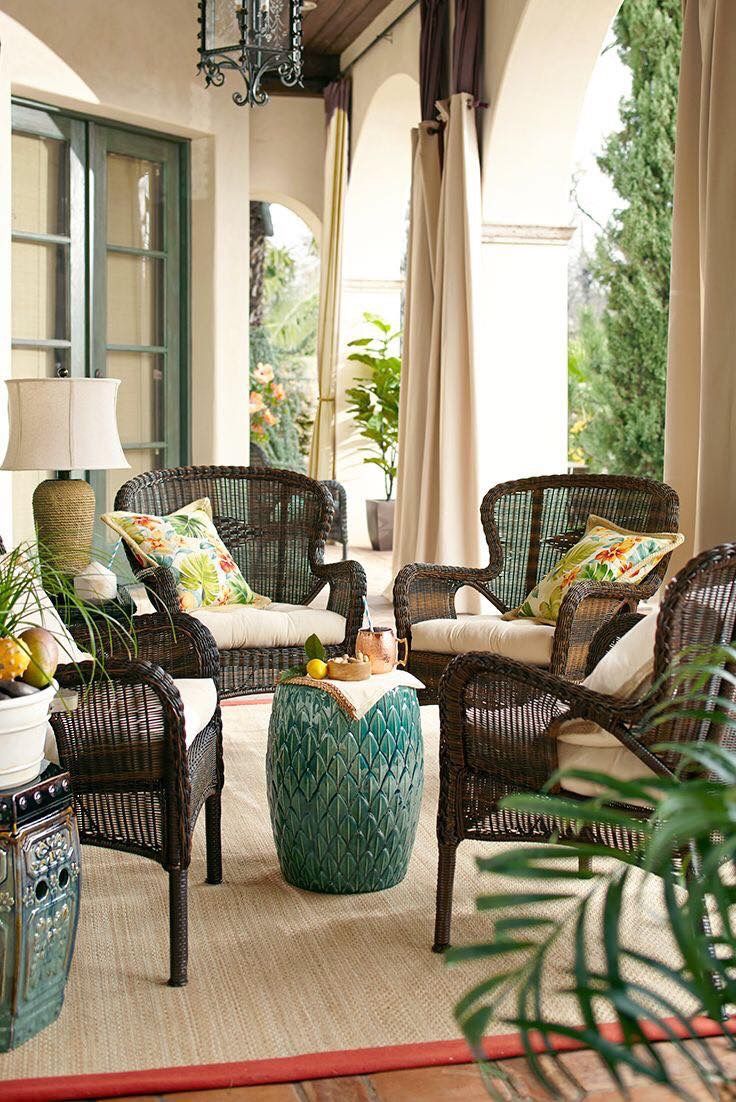 an outdoor living room with wicker furniture