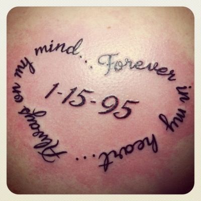 the back of a woman's shoulder with a heart and words written on it