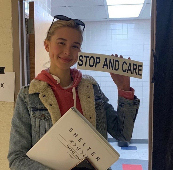 a woman holding up a sign that says stop and care