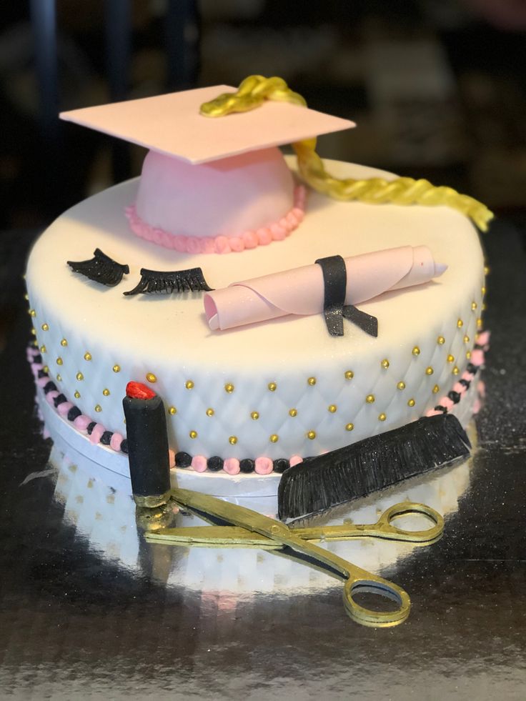 a graduation cake decorated with scissors and hair accessories