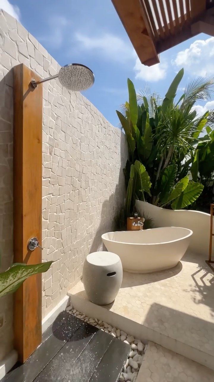 an outdoor bathroom with two sinks and plants