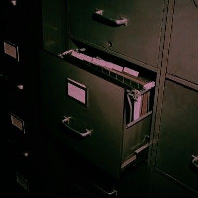 two filing cabinets with file drawers in the middle one is empty and the other has pink labels on them