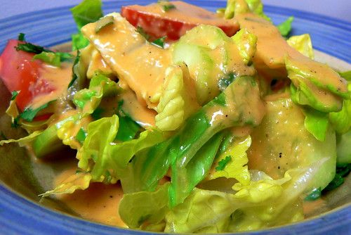 a blue plate topped with salad covered in dressing