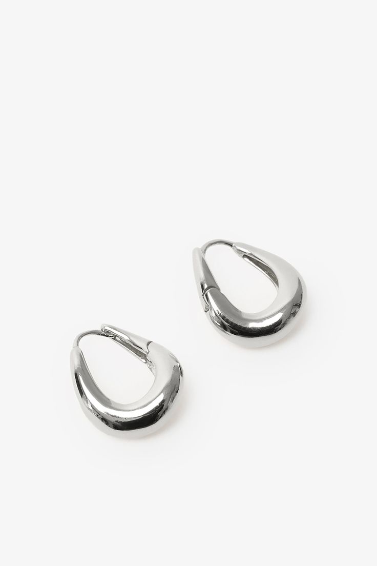 Find poetry in the everyday with our Sisley Hoops. Elegant and ever-so-chunky, these oval ornaments are crafted from sterling silver with either 18k gold or white gold plating to complement any look. Featuring a post back closure and polished finish. Each pair includes a Marcella-branded vegan leather travel case for safe storage and easy travel. | Available in one size. Approximately .5” (1.5 cm) in height, and .3" (.8 cm) in width. In silver, white gold plated sterling silver. In gold, 18KT ye Silver Oval Jewelry For Everyday, Trendy Everyday Jewelry With Polished Finish, Trendy Polished Finish Jewelry For Everyday, Everyday Teardrop Jewelry With Shiny Finish, Silver Oval Tarnish Resistant Hoop Earrings, Everyday Oval Jewelry With Shiny Finish, Silver Hoop Earrings Tarnish Resistant For Everyday Luxury, Trendy Oval Jewelry For Everyday, Oval Jewelry With Shiny Finish For Everyday