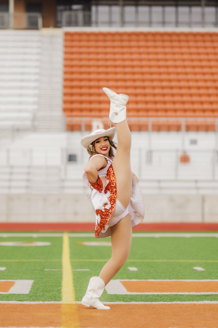 a girl in a cheerleader outfit is on the field