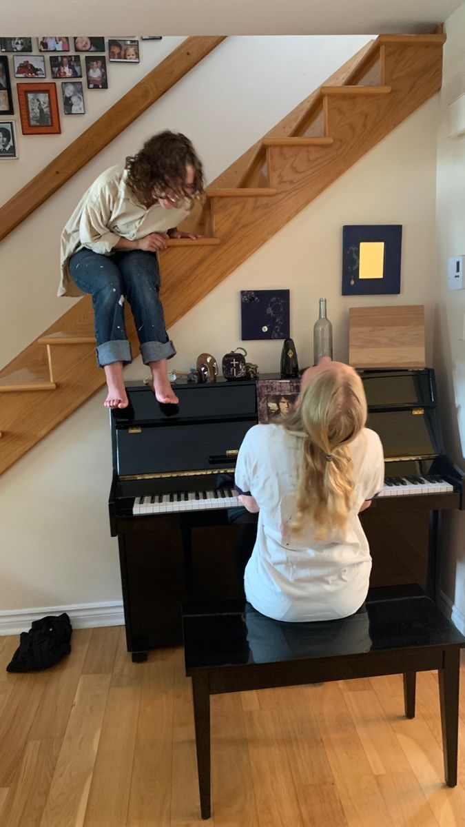 two people are playing piano in the living room